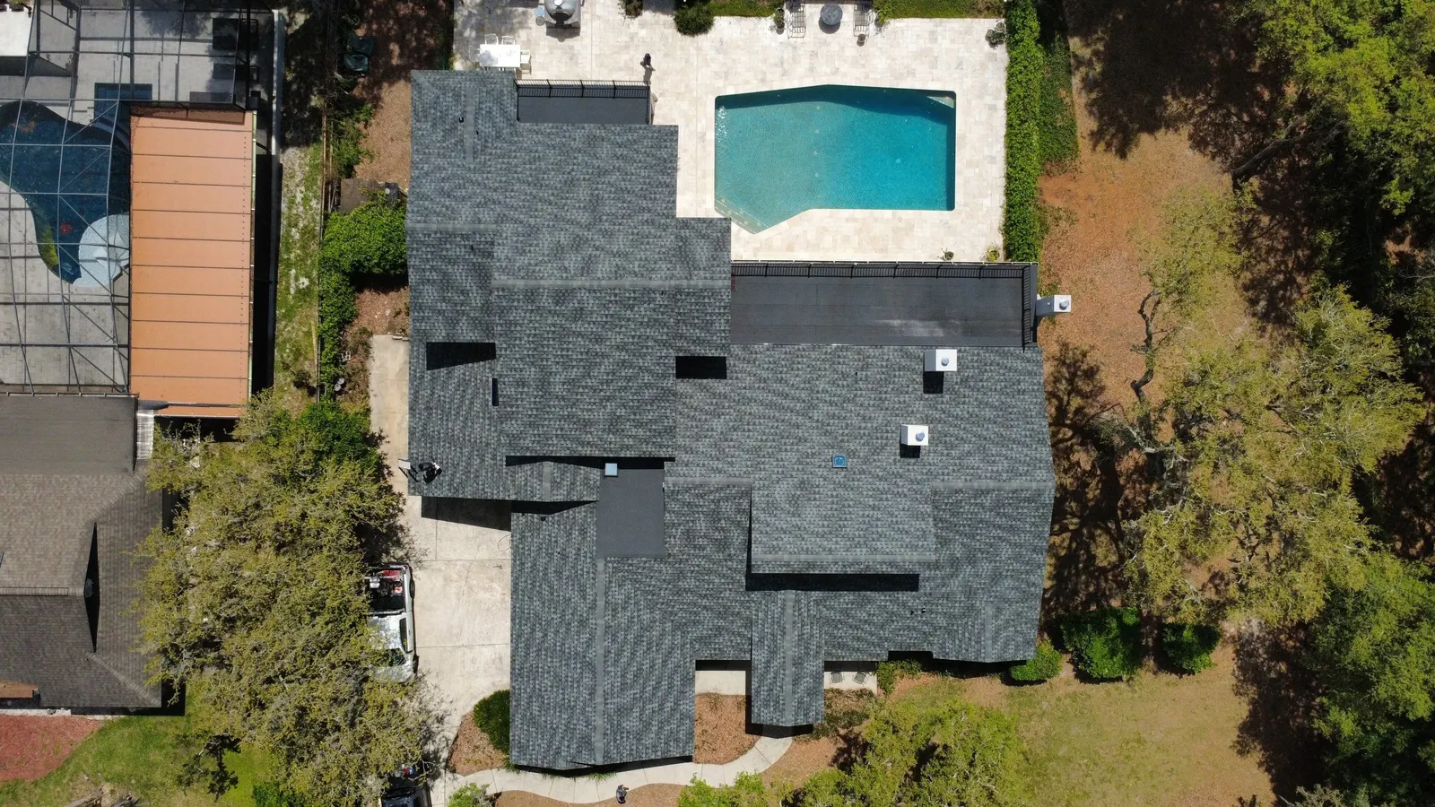 Overhead view of a dark shingle roof on a Lake Mary home with a pool