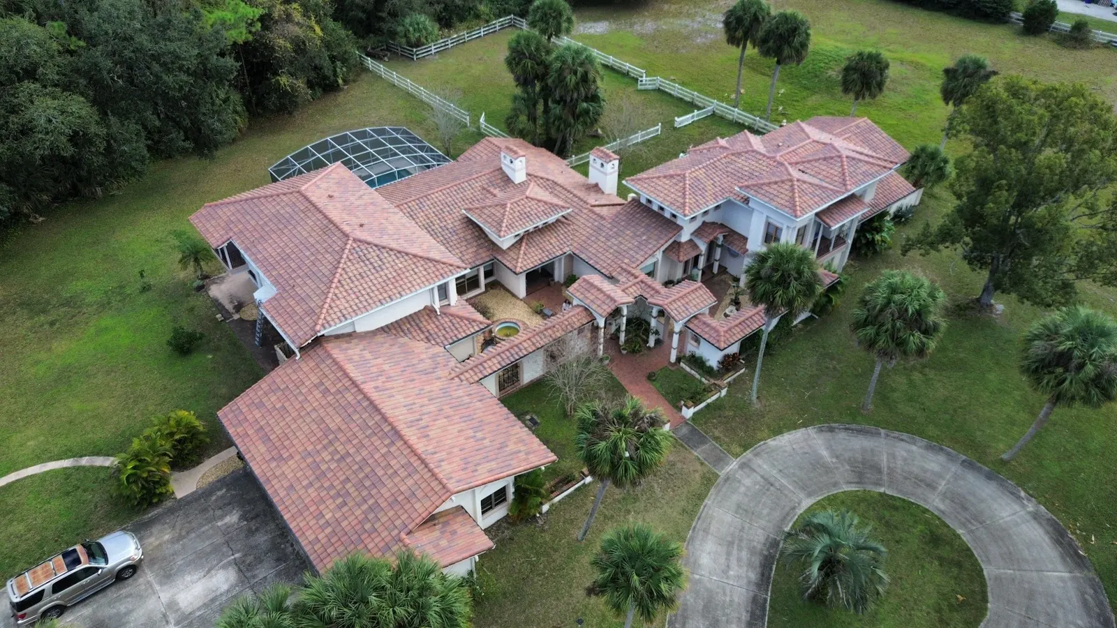 Aerial view of a large tile-roofed estate home in Port Orange