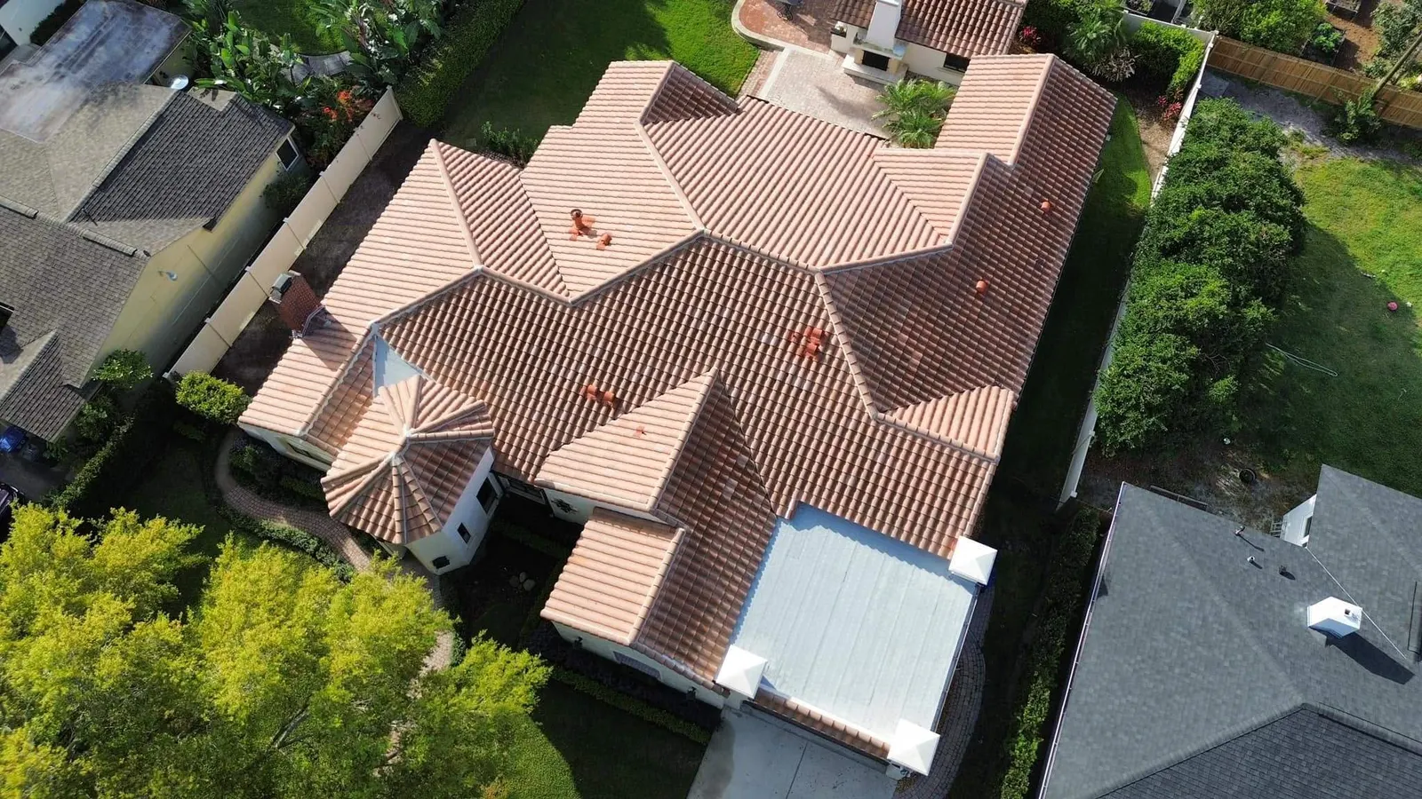Aerial view of a Winter Park home with a barrel tile roof and a flat roof section