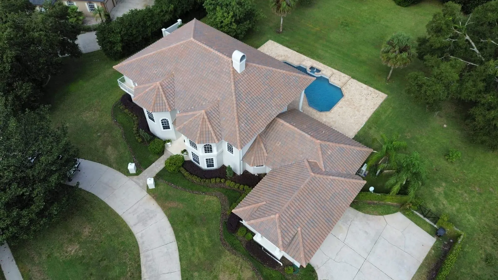 Aerial view of the hip tile roof on a Longwood home beside the pool