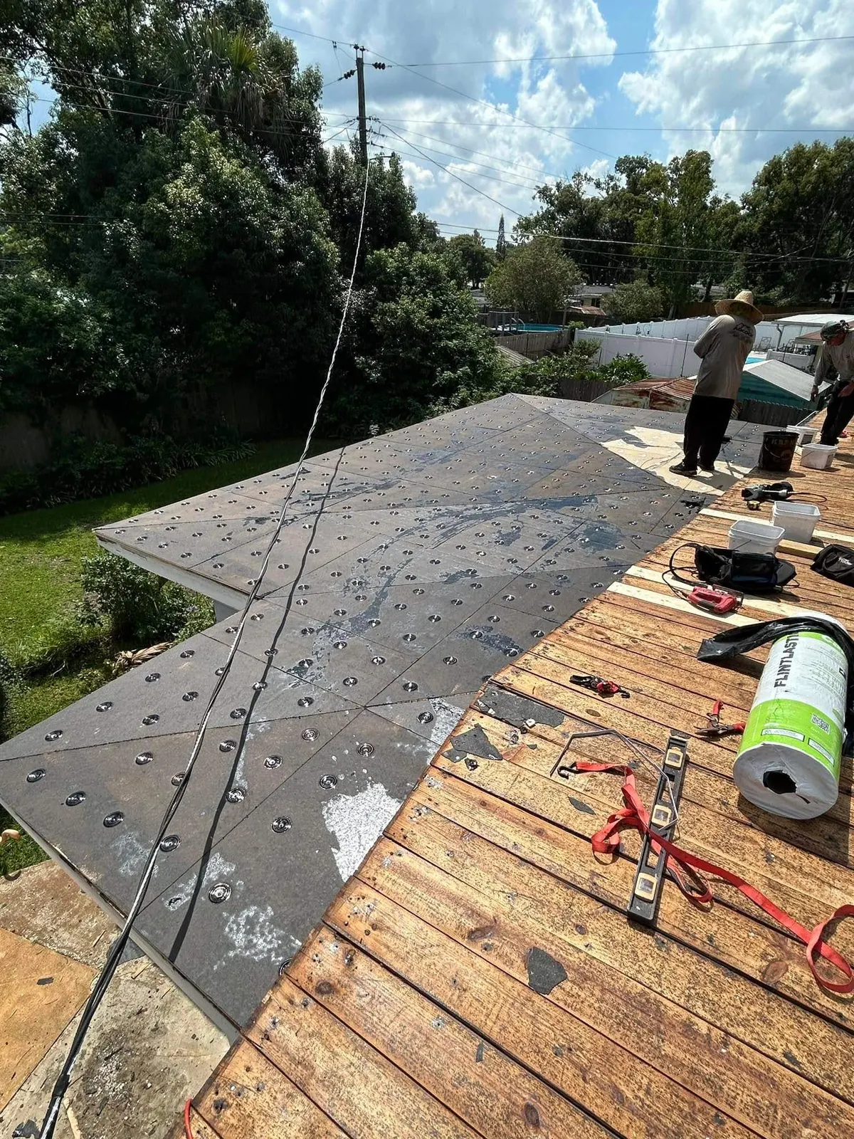 Crew installing the tapered system and base ply on the Sanford flat roof