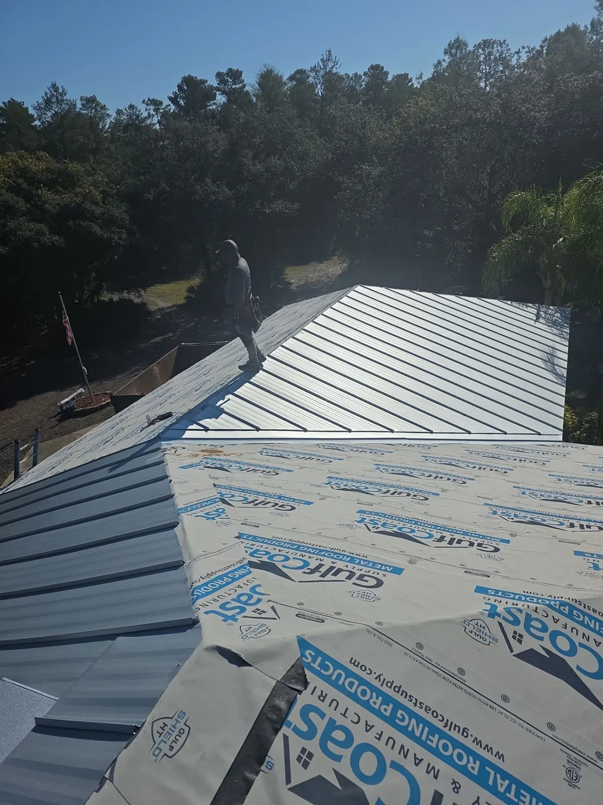 Installer setting standing seam panels over underlayment in DeLand