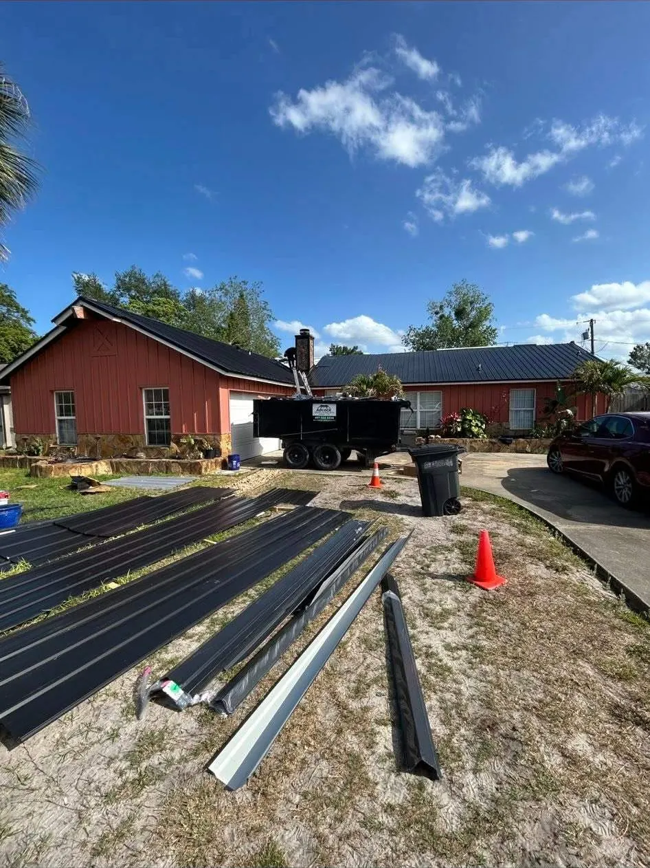 Black rib panels staged in the yard before installation in Deltona