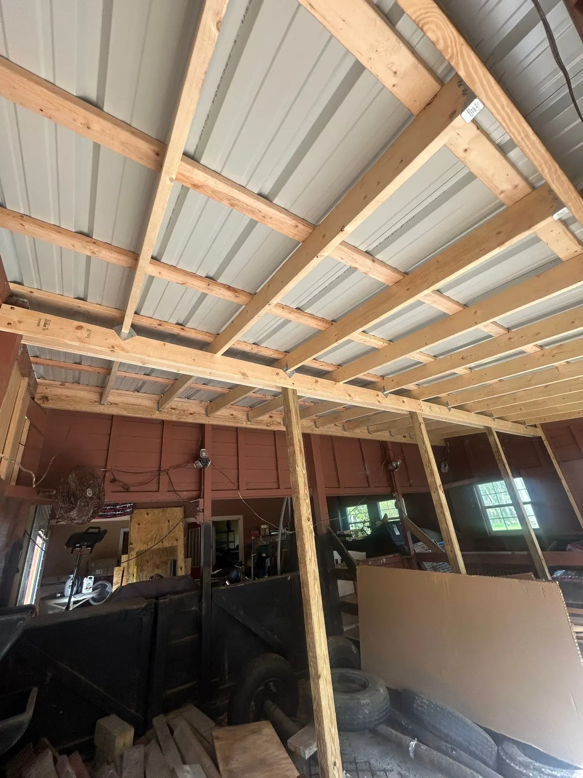 New lumber framing under the barn's metal roof panels